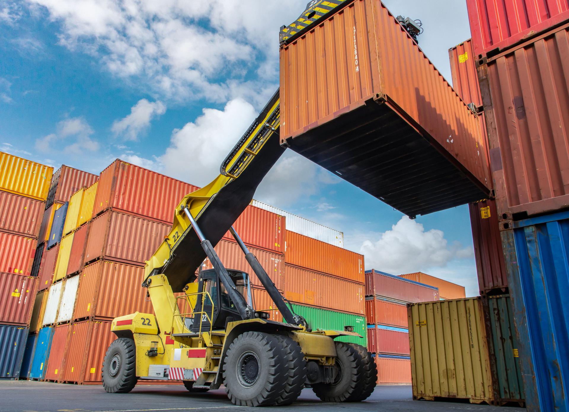 Crane lifting up container in yard